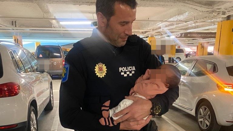 Un agente de la Policía Local de Murcia con el bebé que ha sido rescatado en Murcia del interior de su vehículo (foto: Policía Local de Murcia)