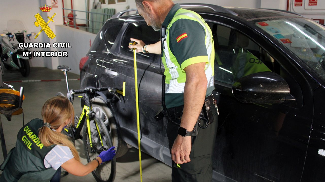 Dos agentes de la Guardia Civil junto a la bicicleta y el coche implicados (foto: GC)