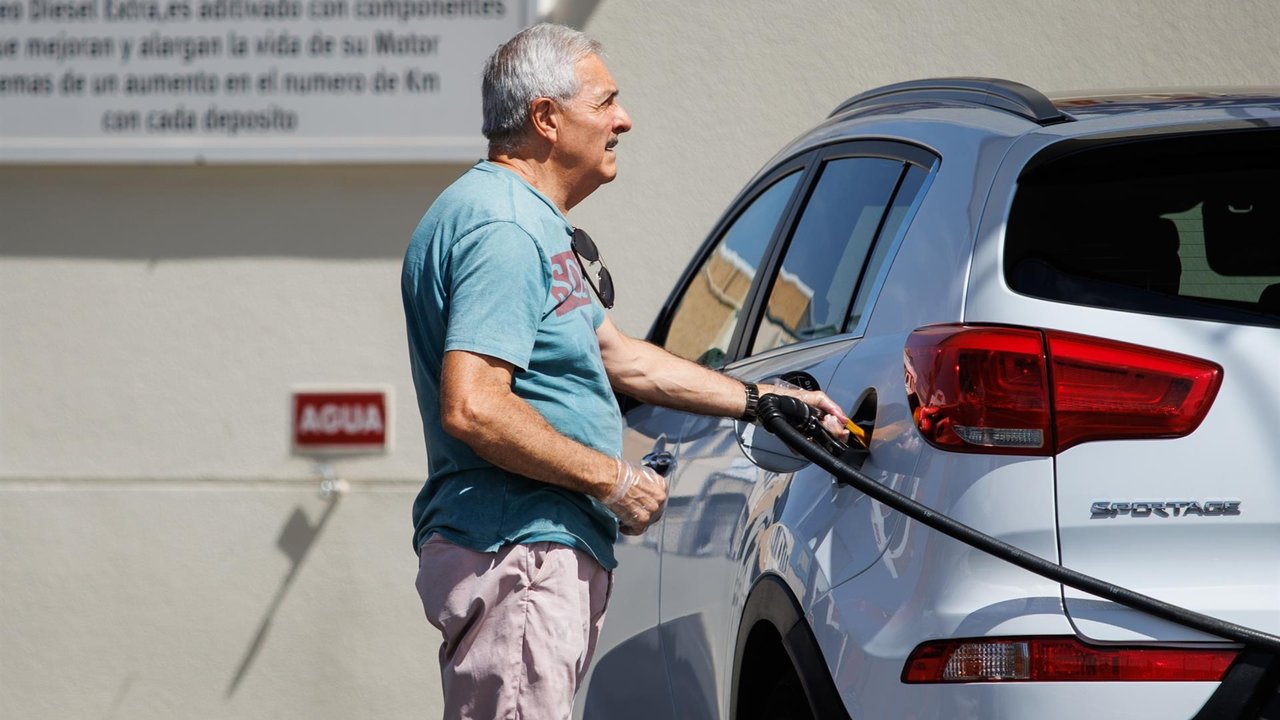 Un hombre echa carburante a su vehículo en una estación de servicio